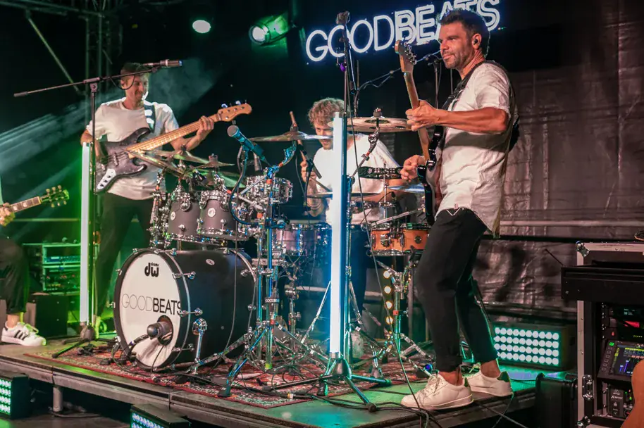 GOODBEATS live in Hövelhof: Sänger mit Akustikgitarre in der Mitte, Bass links, Schlagzeug dahinter — Schwarz-Weiß-Aufnahme